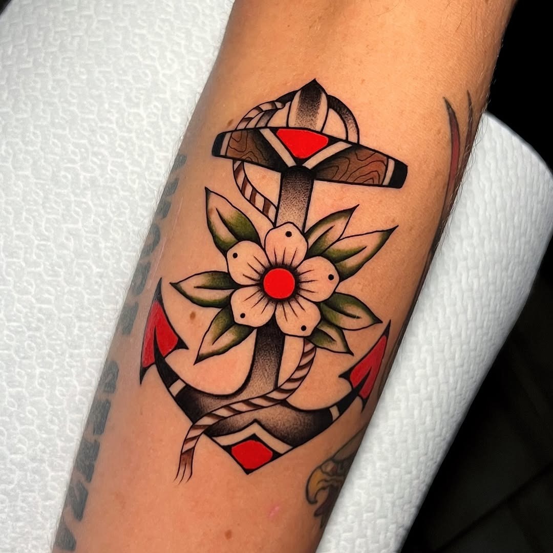 Traditional anchor tattoo with vibrant floral accents Tattoo Design