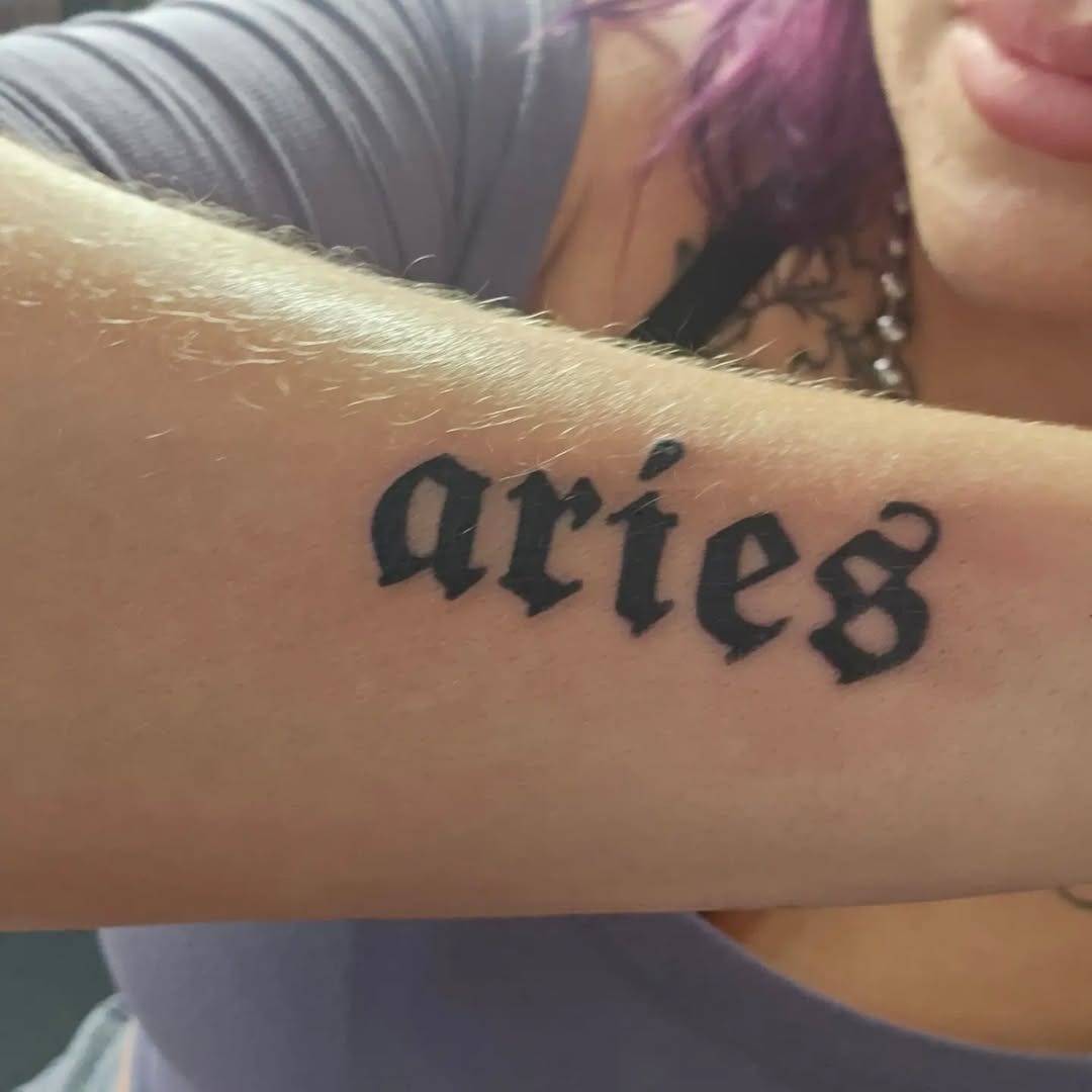 Bold Script Aries Tattoo on Forearm Tattoo Design