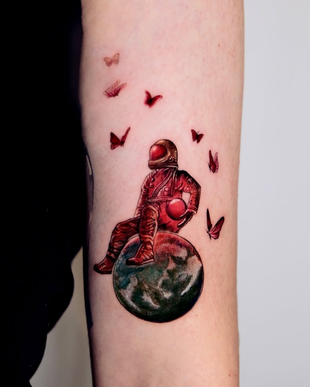 Vibrant astronaut tattoo with butterflies and globe Tattoo Design