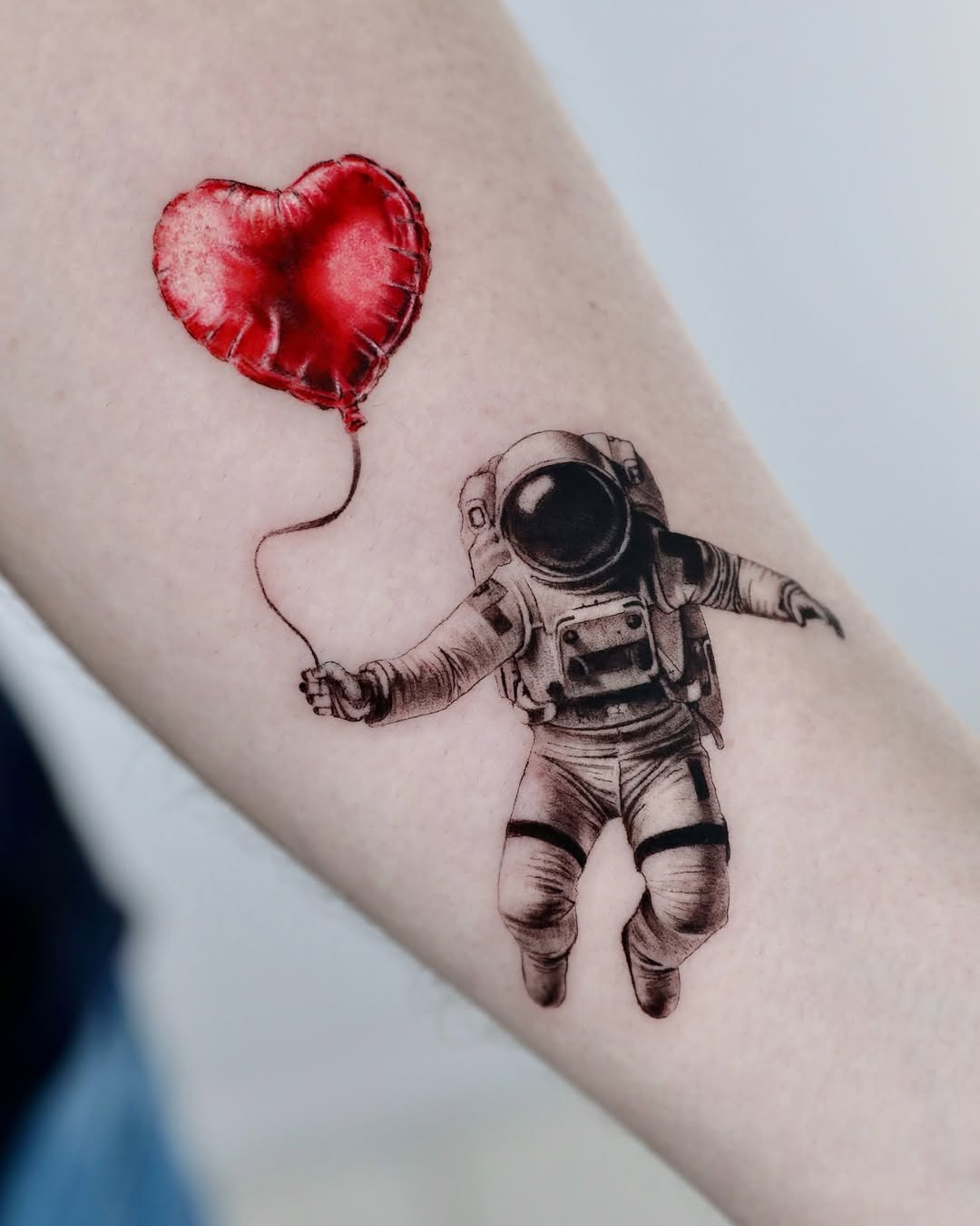 Whimsical astronaut holding a heart balloon tattoo Tattoo Design