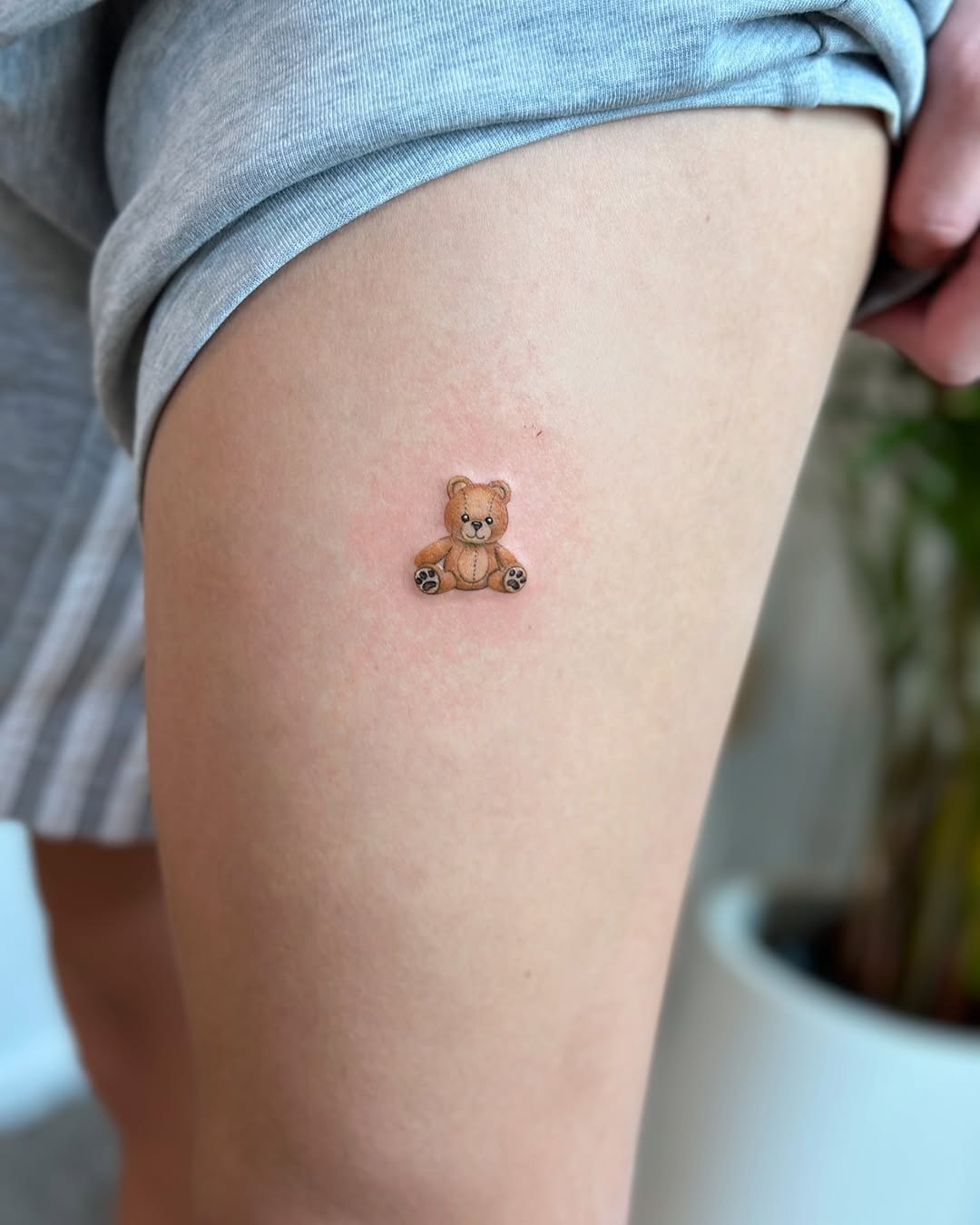 This cute bear tattoo sits playfully on the thigh, exuding a charming vibe.