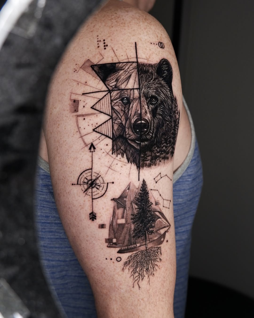 This stunning bear tattoo showcases a beautifully detailed bear head intertwined with geometric shapes and natural elements.