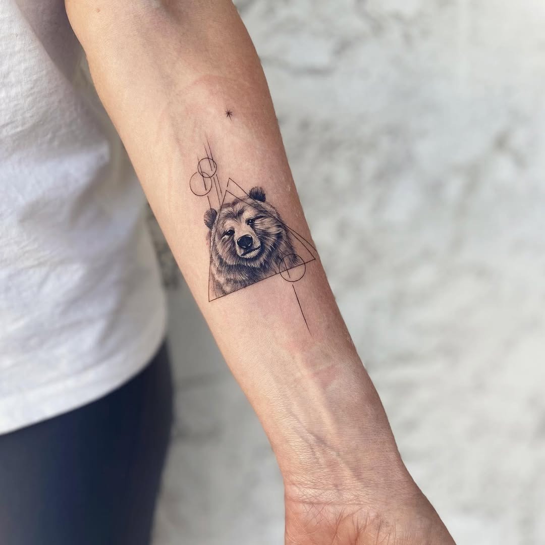 This tattoo features a realistic bear head surrounded by geometric shapes, giving it a modern touch.