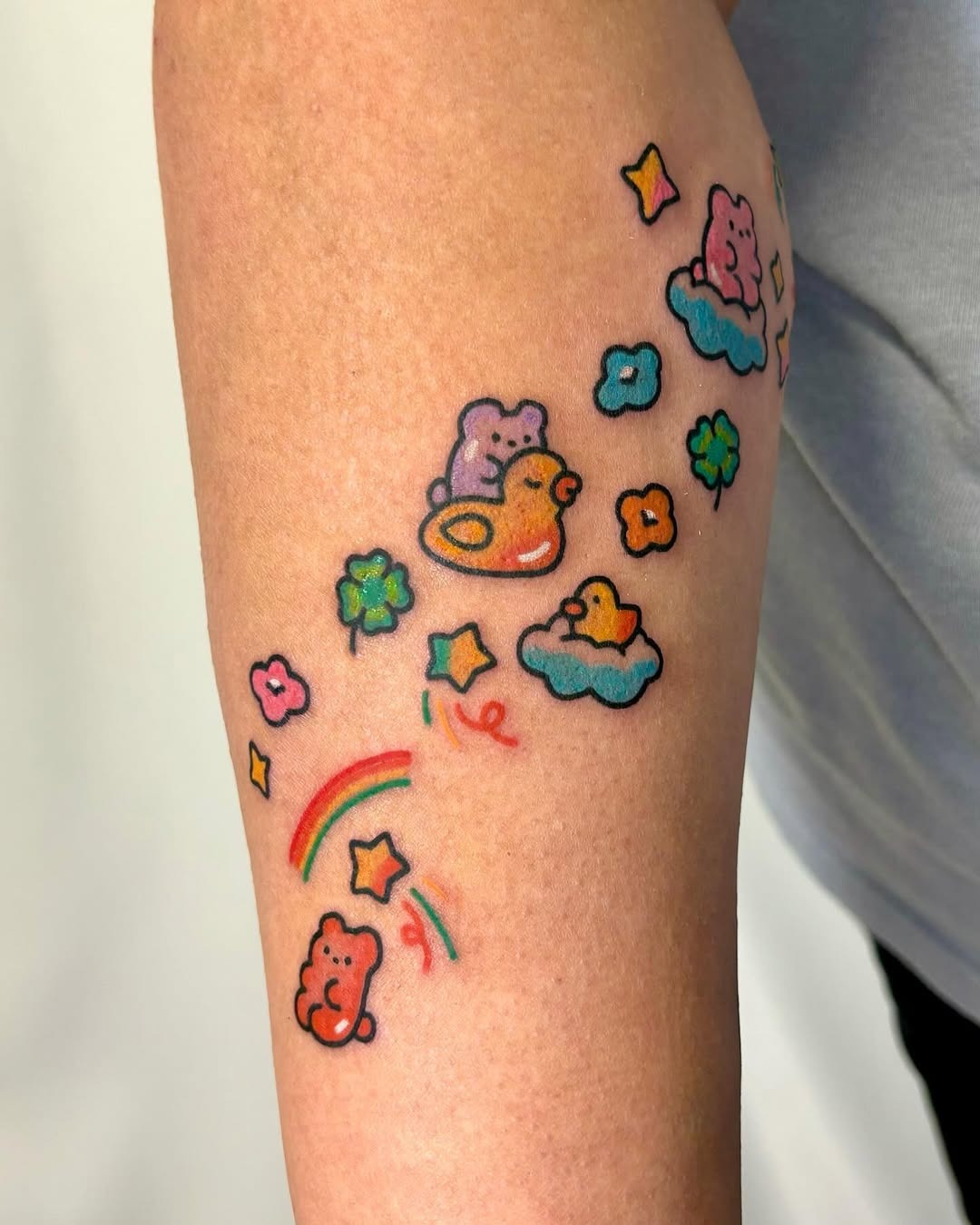 This bear tattoo features adorable cartoon bears floating among clouds and a rainbow.