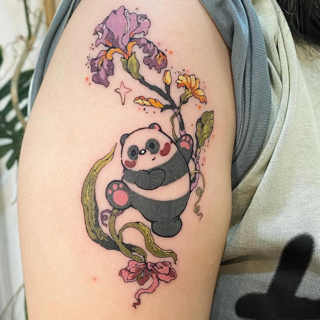 This whimsical bear tattoo features a charming panda playfully holding onto a decorative floral design.