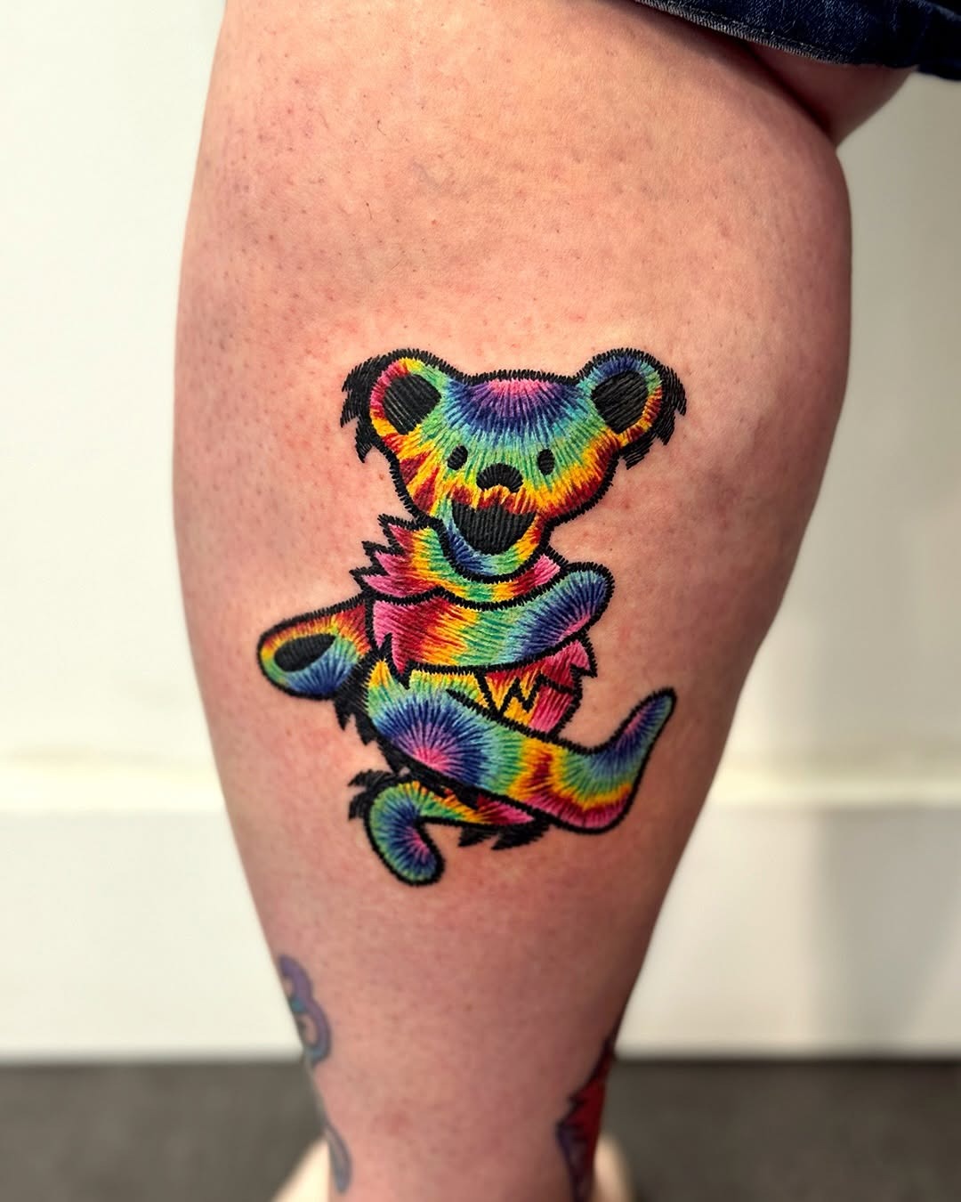 This bear tattoo features a playful and design that bursts with colors.
