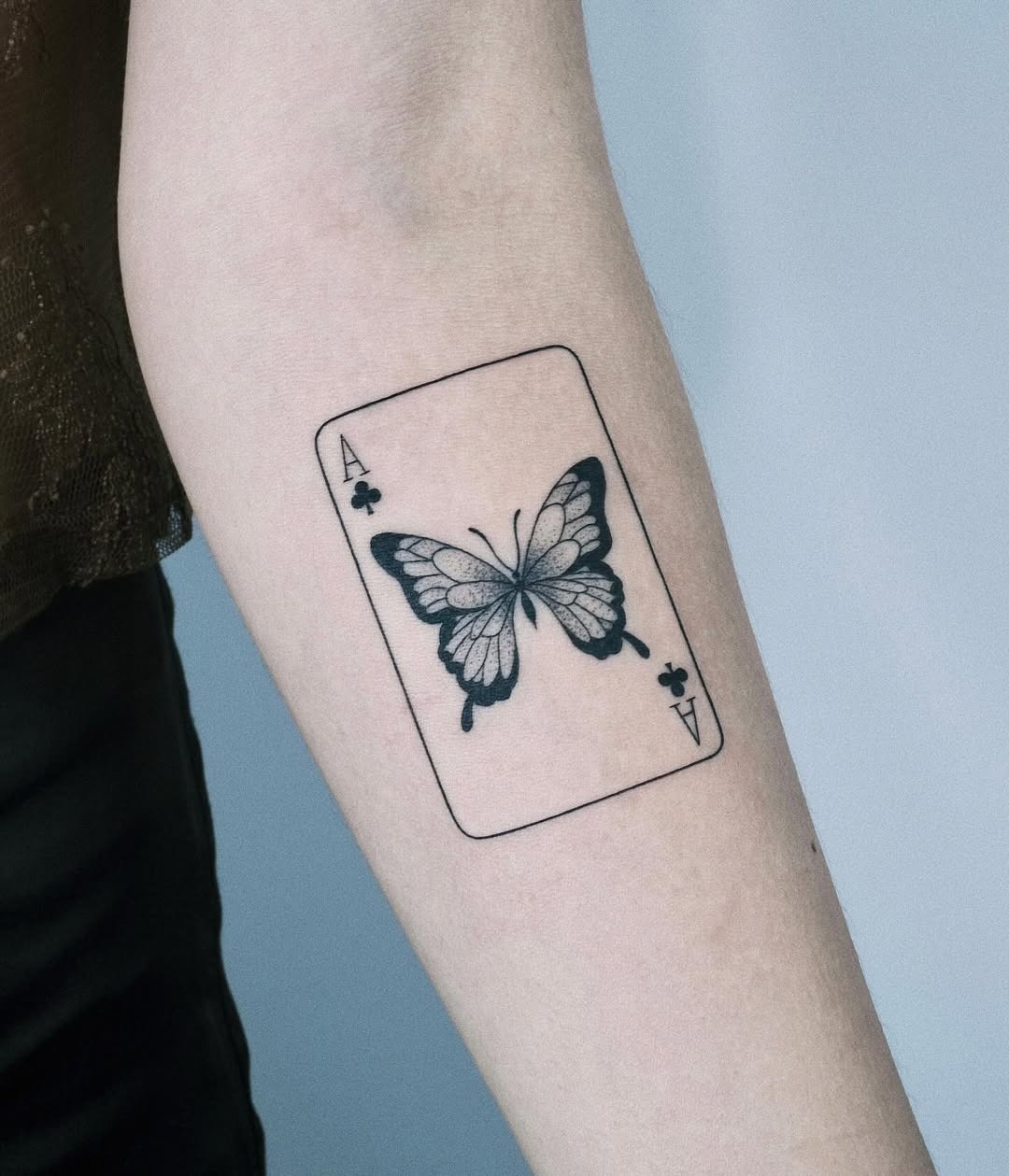 This unique tattoo features a butterfly beautifully illustrated within the confines of a playing card.