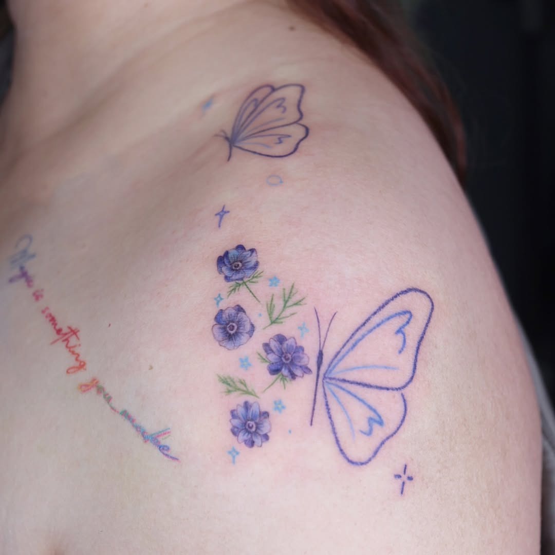 This tattoo features a beautiful butterfly paired with charming flowers, creating a soft and whimsical vibe.