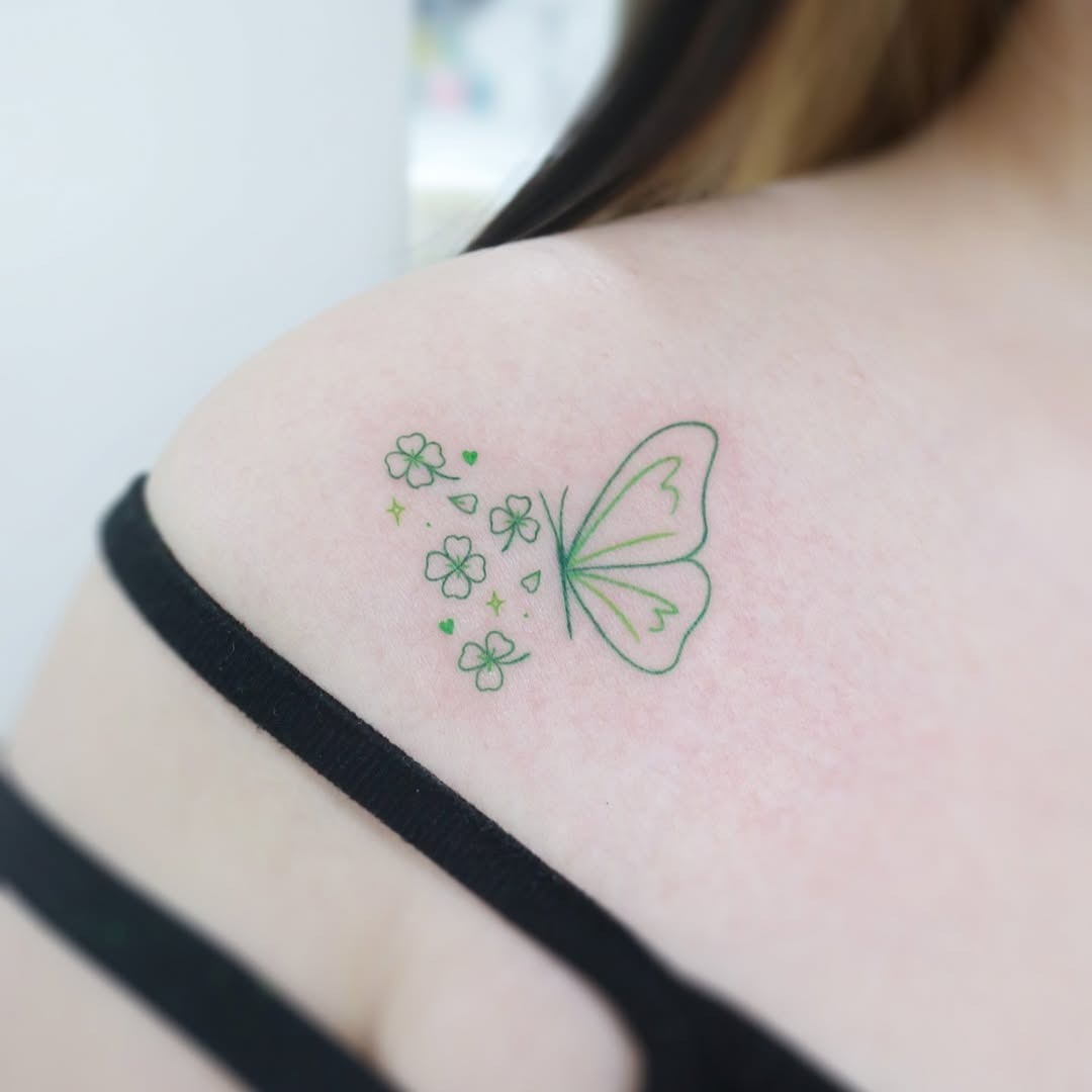 This charming tattoo features a light green butterfly gracefully adorned with small, blooming flowers.