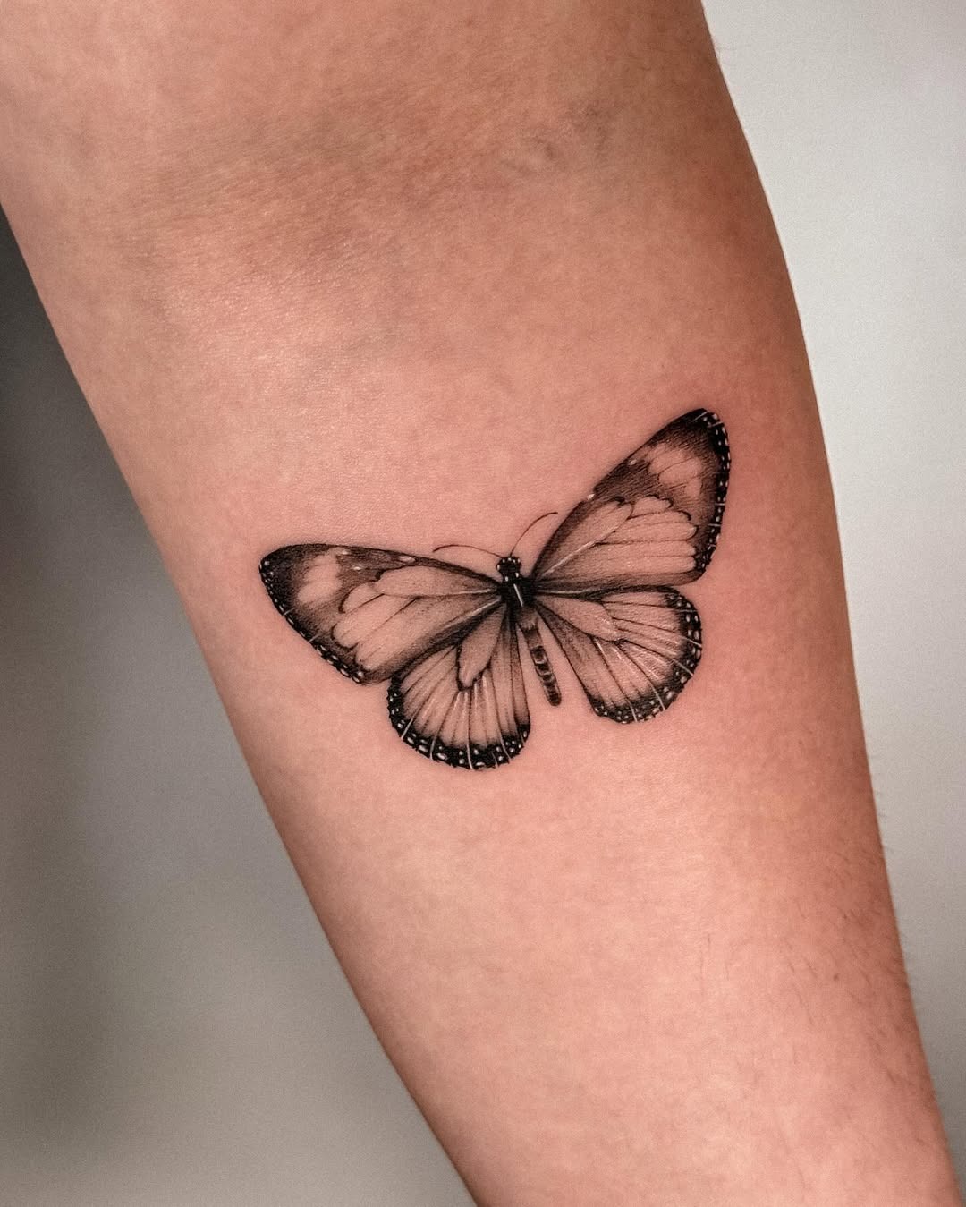 This butterfly tattoo features exquisite detailing with fine line work.