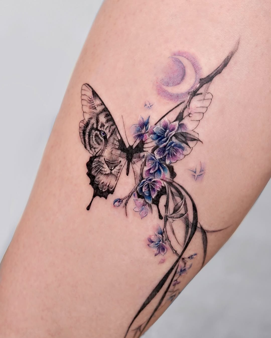 This tattoo features a stunning butterfly surrounded by delicate flowers, creating a harmonious design.