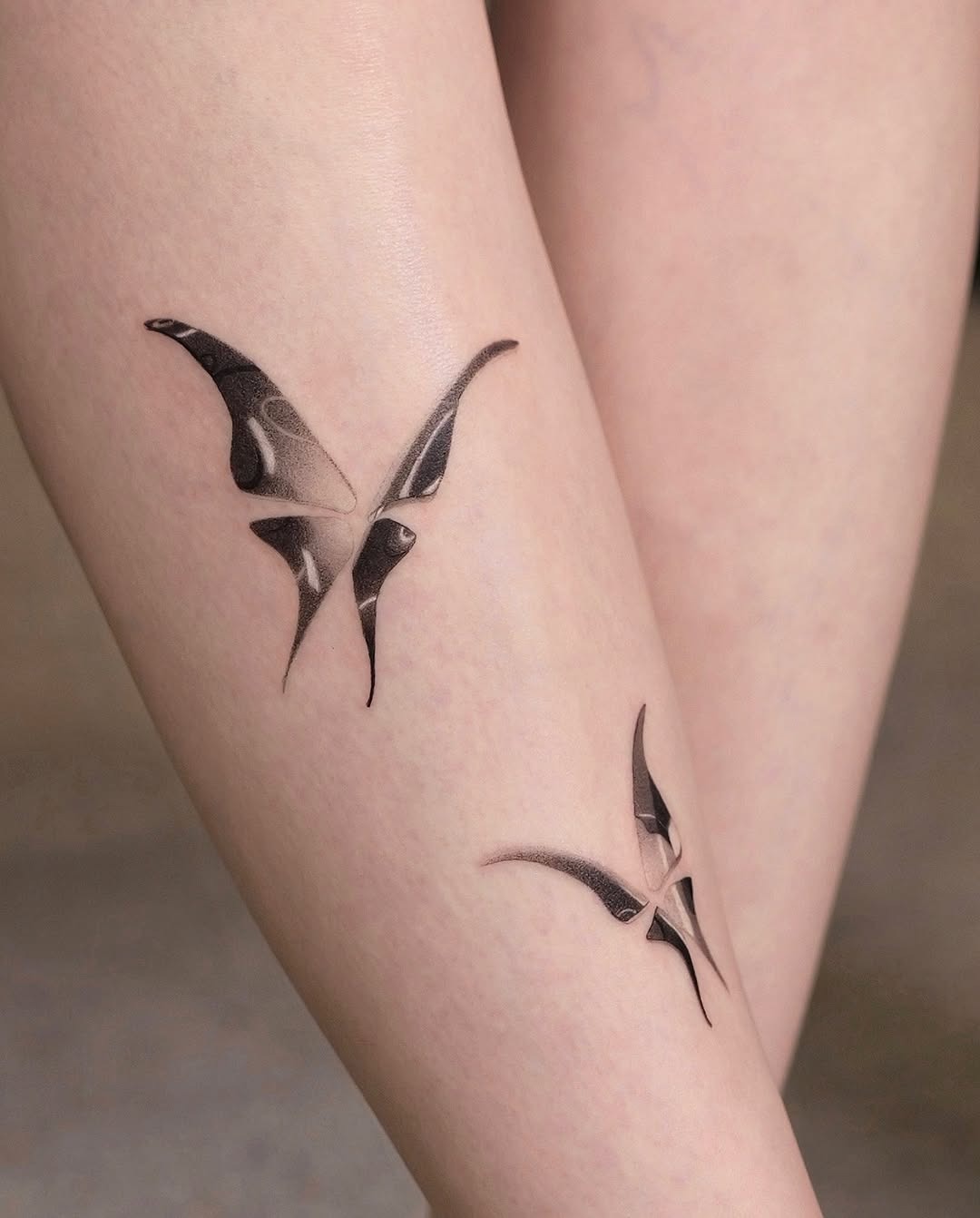 These butterfly tattoos showcase an elegant and modern design, blending artistry with skin.
