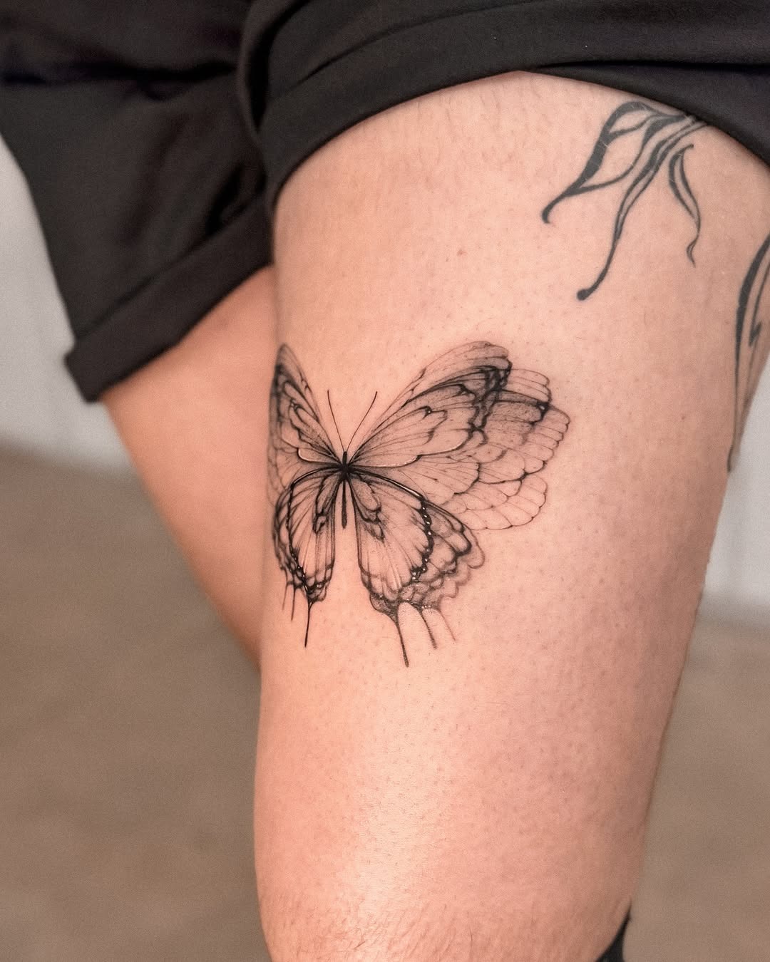 This detailed butterfly tattoo graces the leg with its elegant wings.