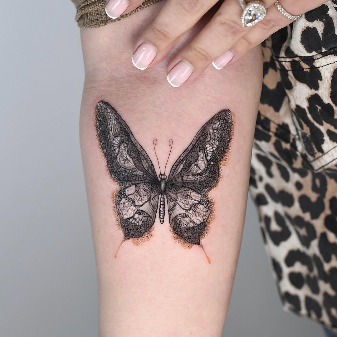 This butterfly tattoo showcases stunning lace-like details, creating a delicate and elegant vibe.