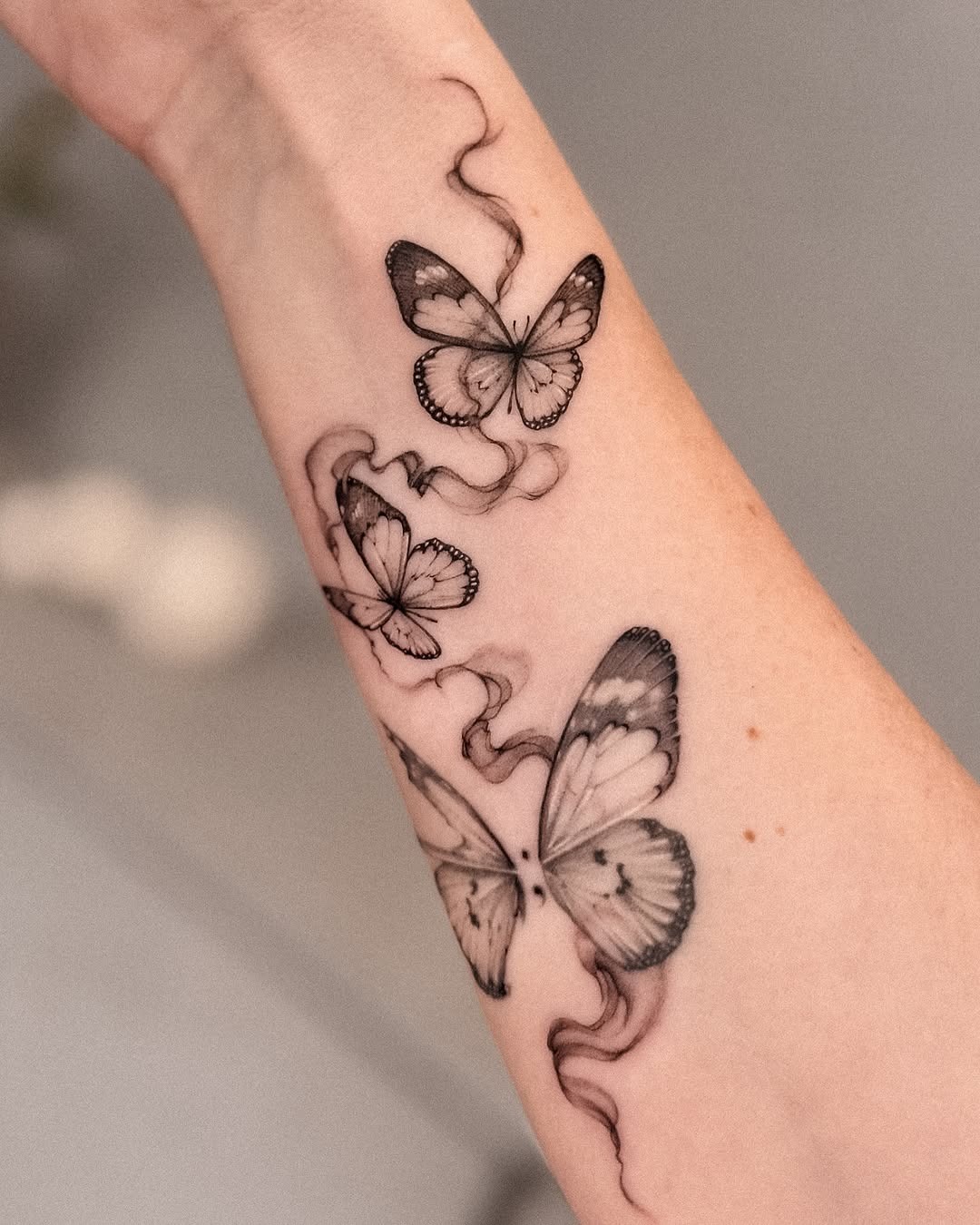 This image showcases delicate butterfly tattoos gracefully inked on the arm.