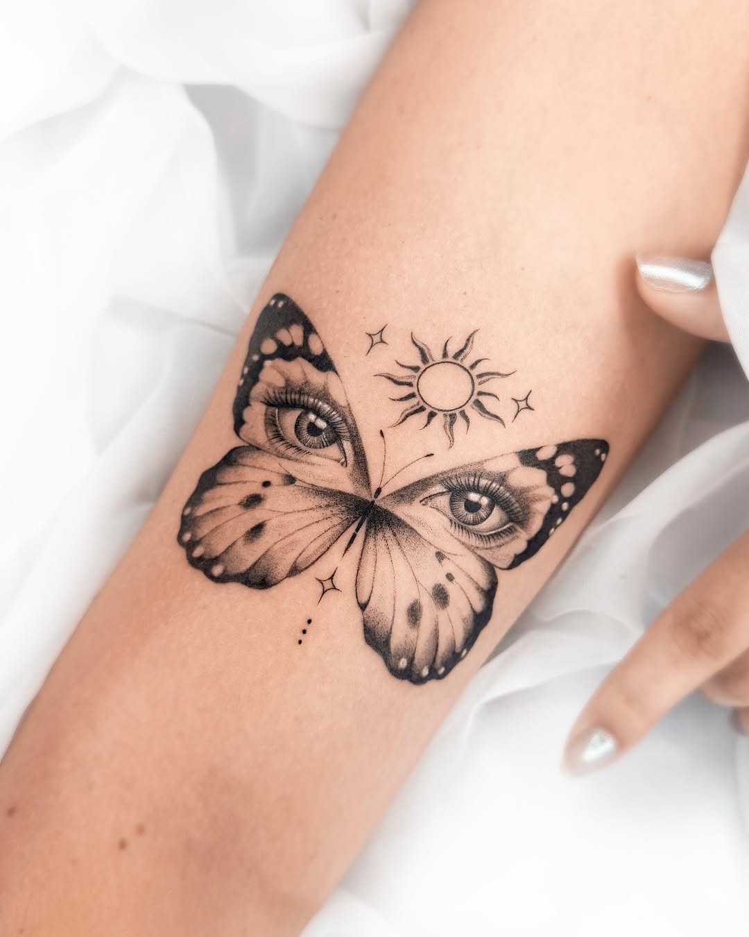 This butterfly tattoo features intricate eyes within the wings, conveying a sense of mystery and insight.