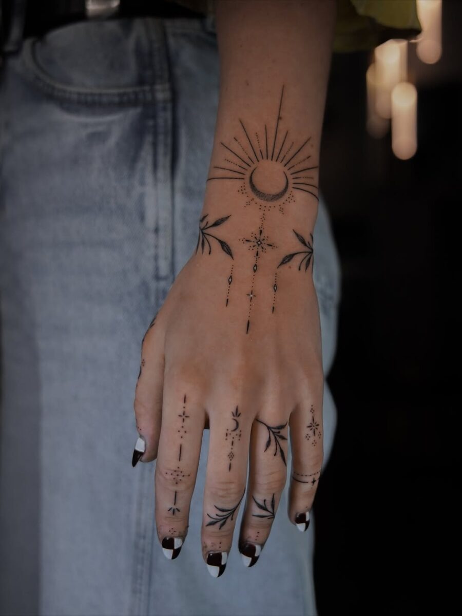 Artistic celestial tattoos adorn the hand beautifully Tattoo Design
