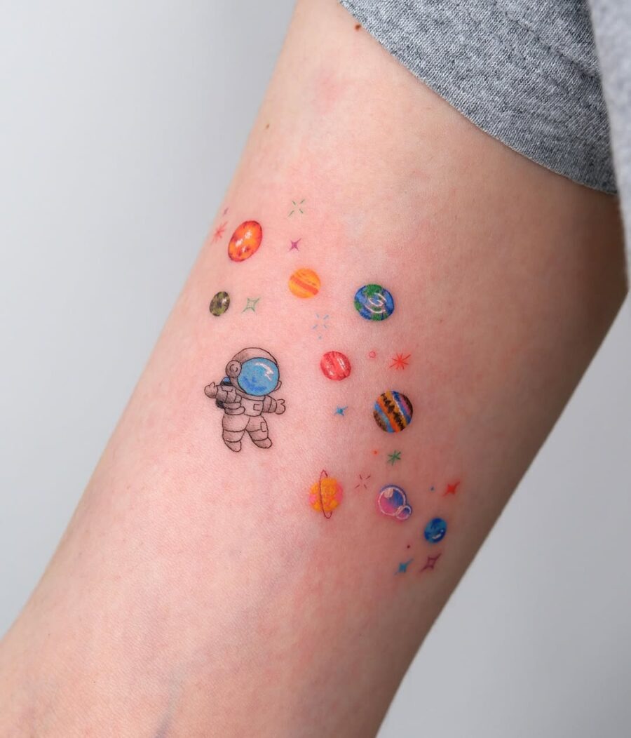 Whimsical Astronaut Among Vibrant Planets Tattoo Design