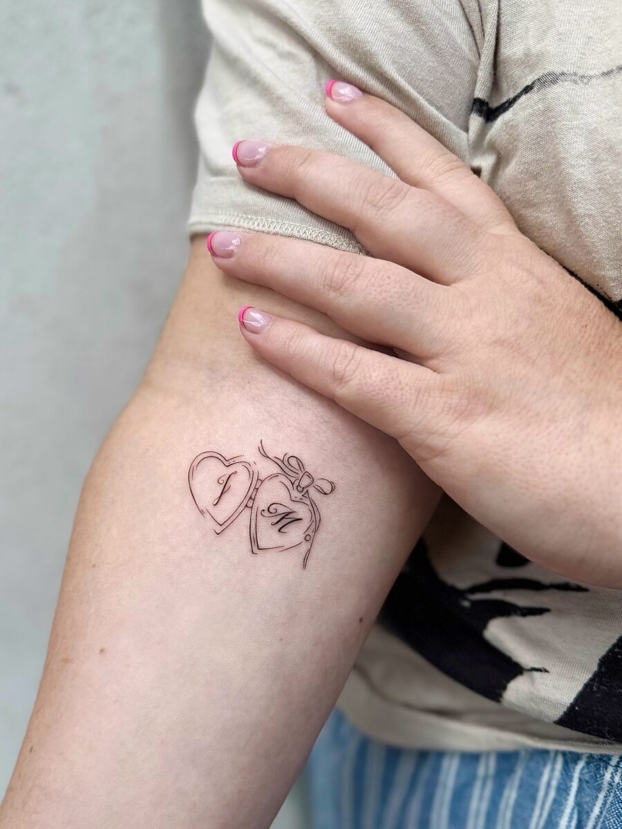 Charming heart-shaped tattoo with bow detail Tattoo Design