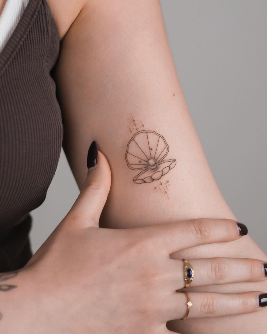 Elegant shell tattoo adorned with delicate stars Tattoo Design