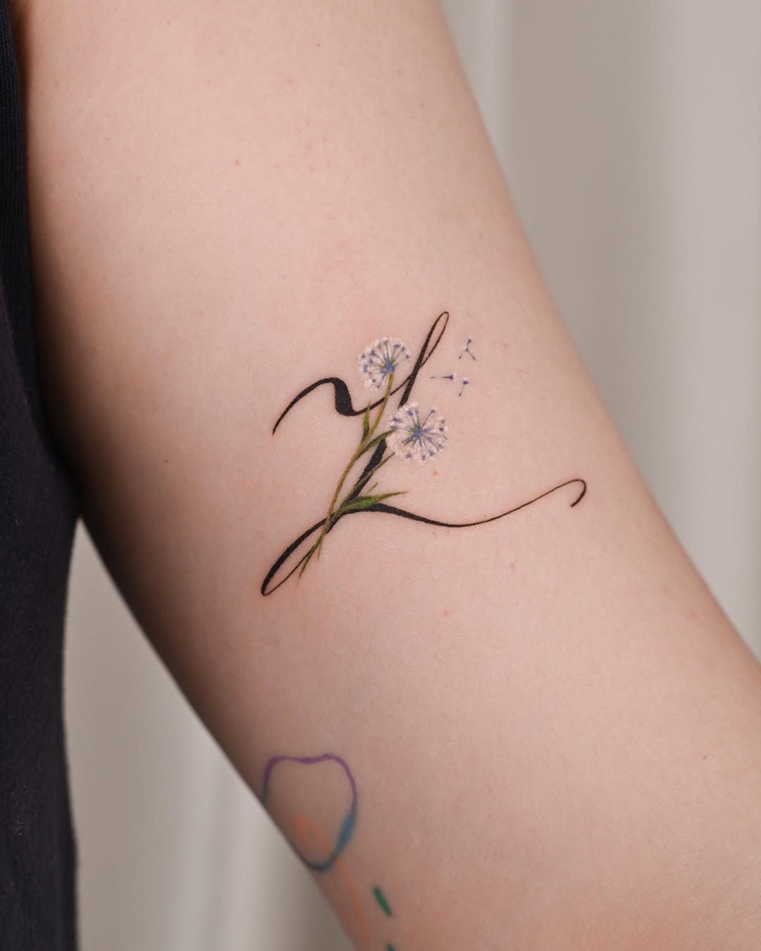 Elegant dandelion tattoo with flowing script Tattoo Design