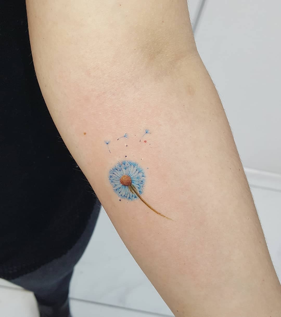 Vibrant blue dandelion tattoo on the arm Tattoo Design