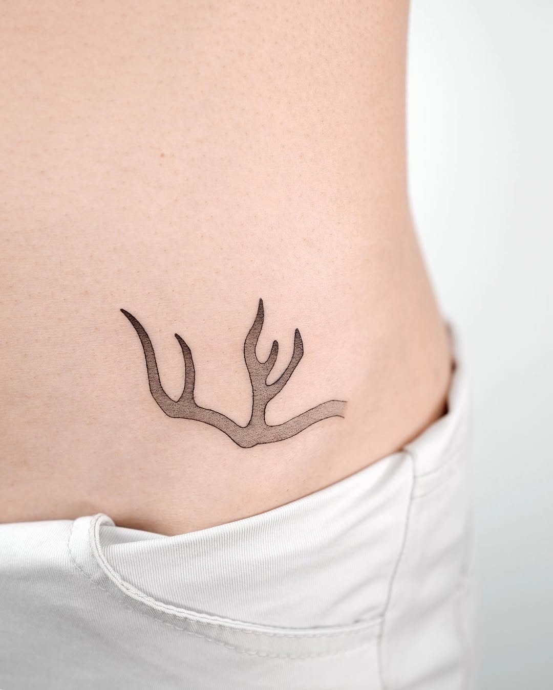 Elegant minimalist antler tattoo on the side Tattoo Design