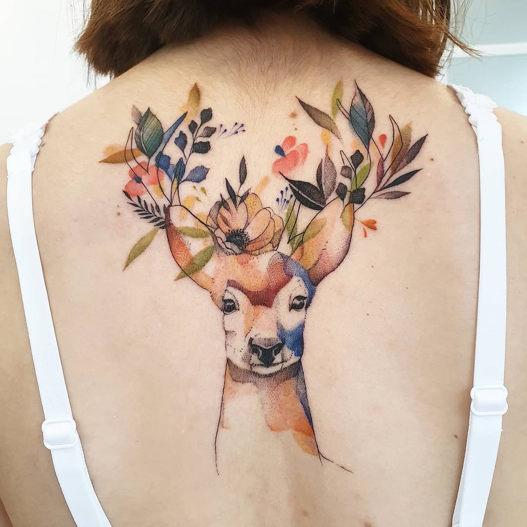 Vibrant watercolor deer tattoo with floral accents Tattoo Design