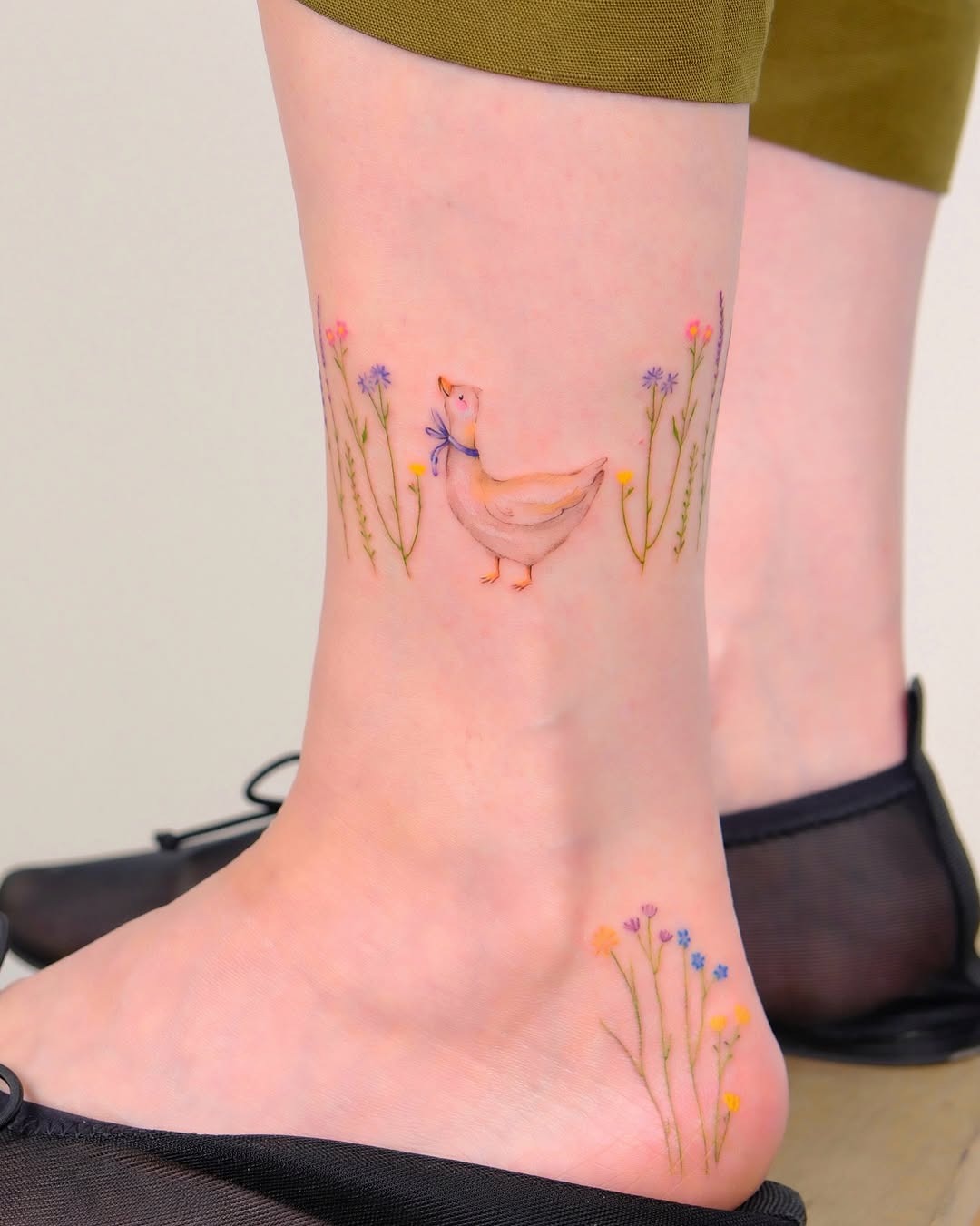 Charming duck tattoo surrounded by colorful flowers Tattoo Design