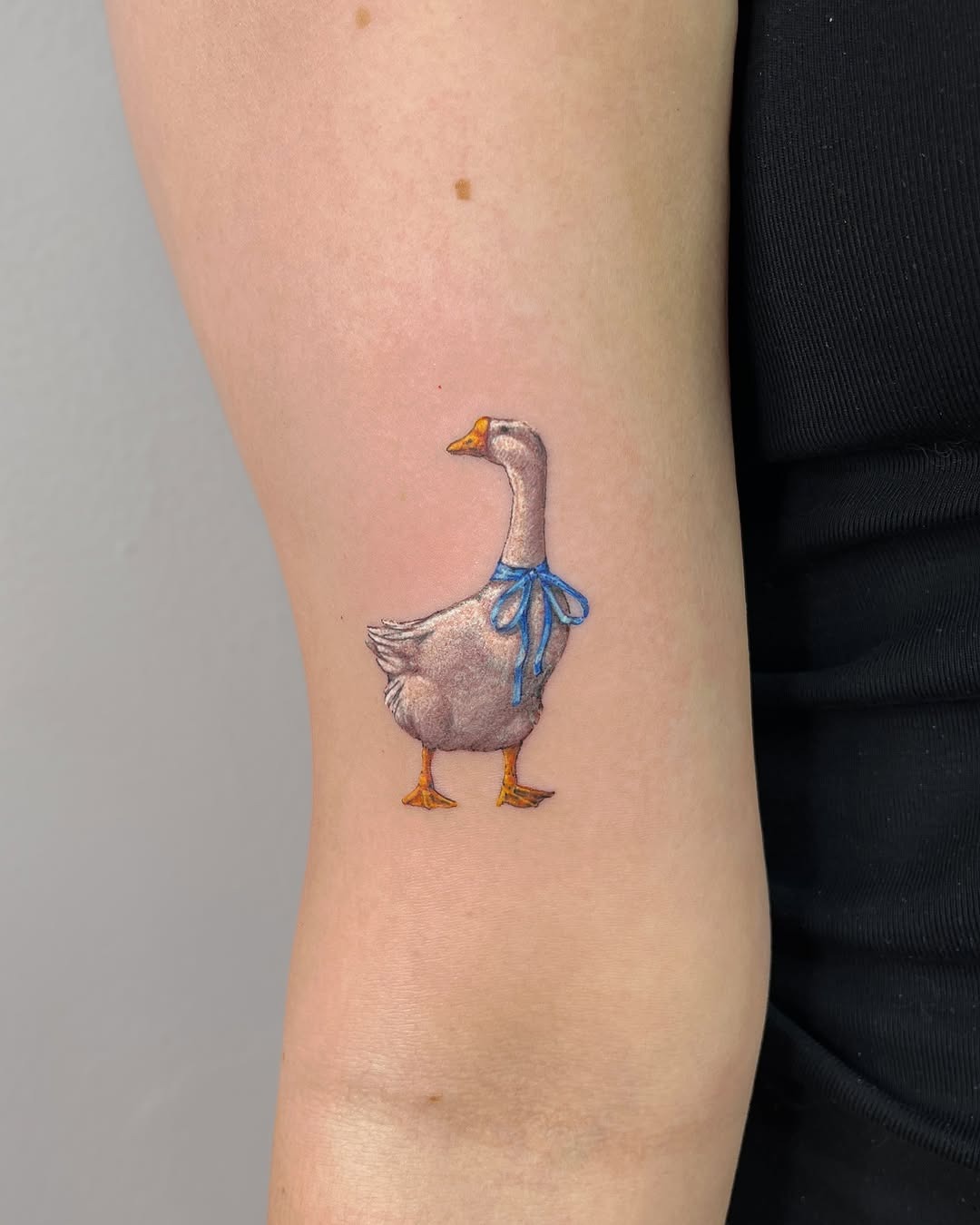 Charming duck tattoo with a blue ribbon Tattoo Design
