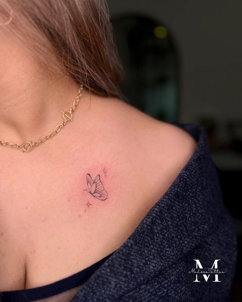 Small Butterfly with Sparkles on the Collarbone Tattoo Design