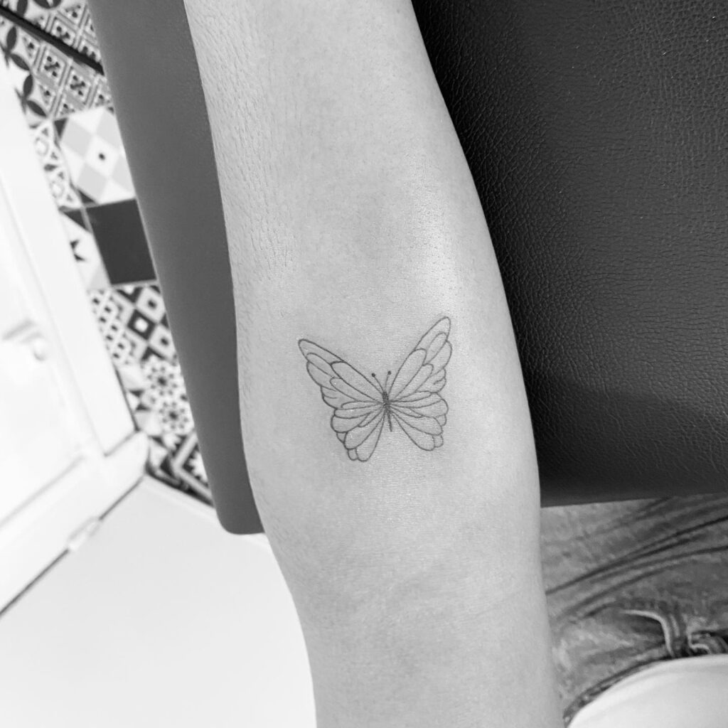 Small Fine Line Butterfly on the Arm Tattoo Design