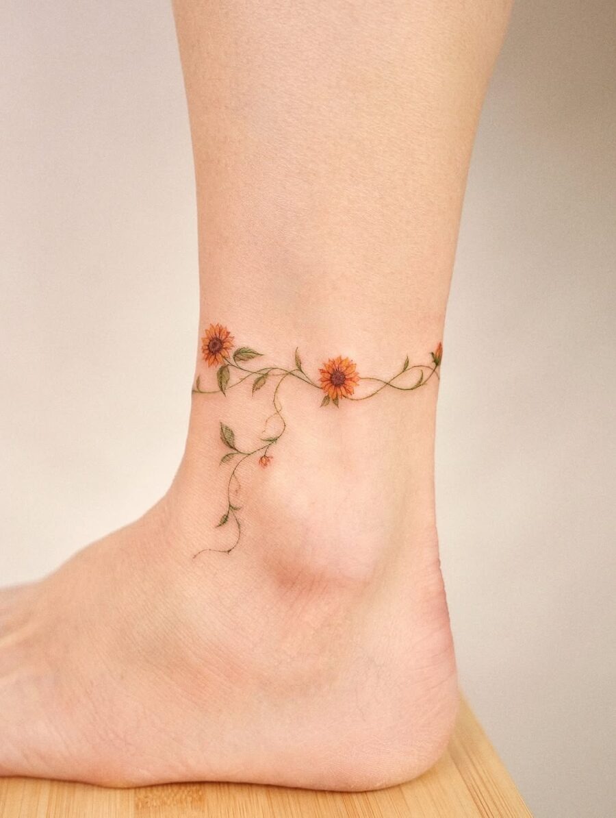 Delicate floral design wrapping around the ankle Tattoo Design