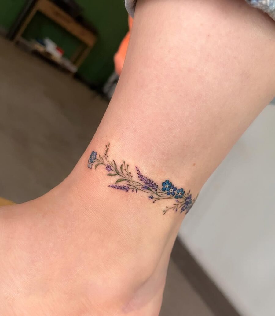 Elegant floral ankle tattoo in vibrant colors Tattoo Design