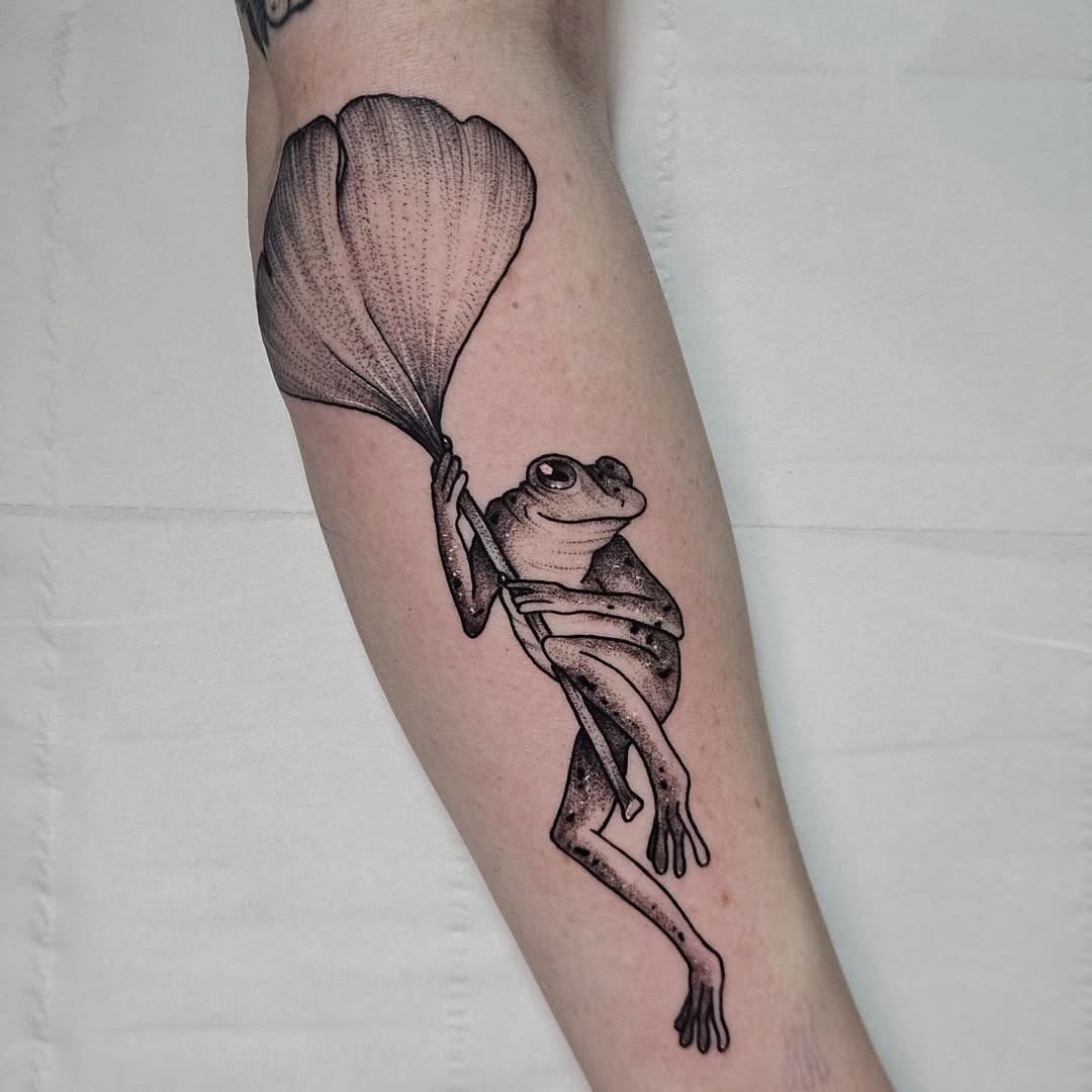 Unique frog tattoo holding a leaf design Tattoo Design
