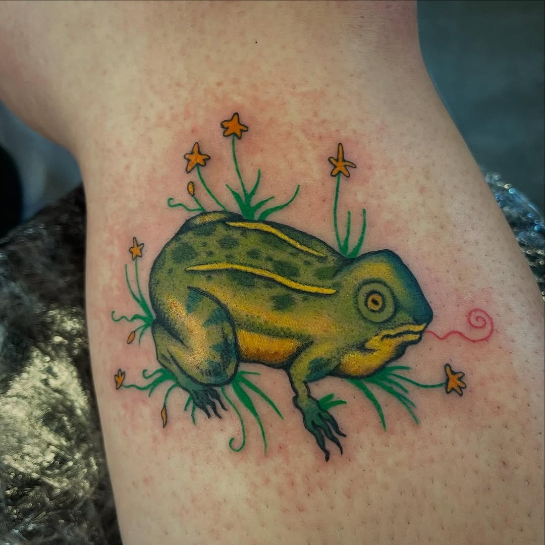 Vibrant frog tattoo surrounded by wildflowers Tattoo Design