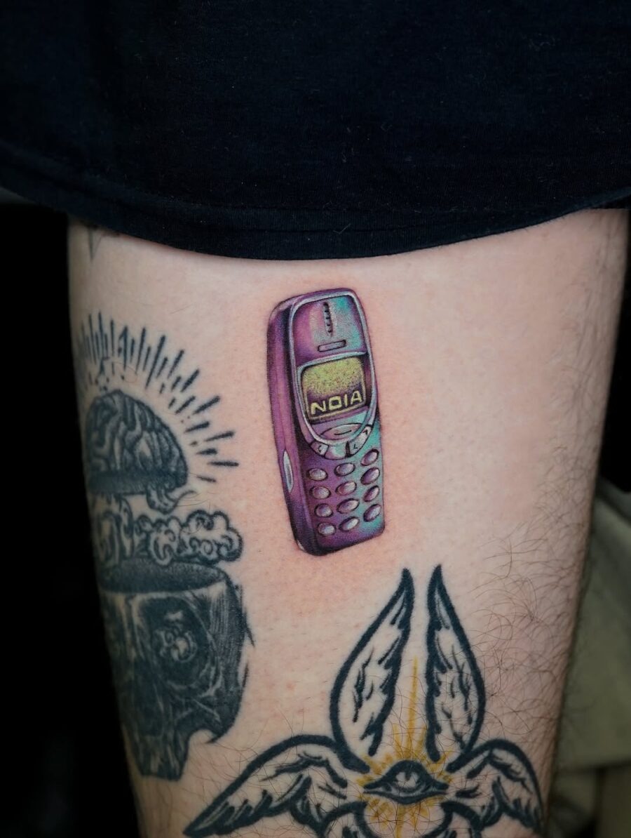 Humorous donut tattoo with a cheeky expression Tattoo Design