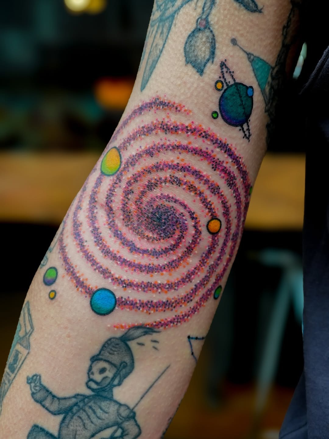 Colorful spiral galaxy tattoo on forearm Tattoo Design