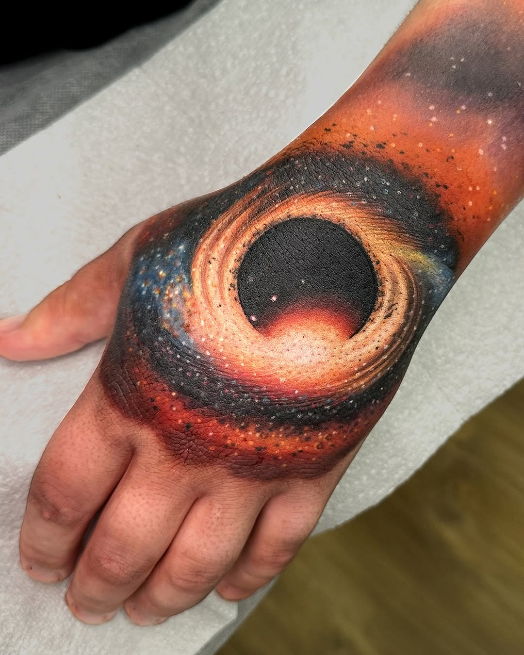 Mesmerizing hand tattoo of a black hole Tattoo Design