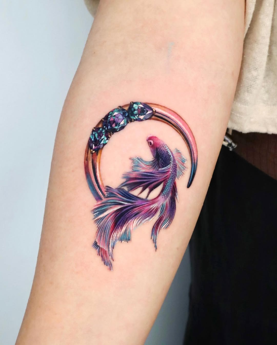 This stunning tattoo showcases a koi fish, captured mid-swim, with flowing fins and a colorful body.