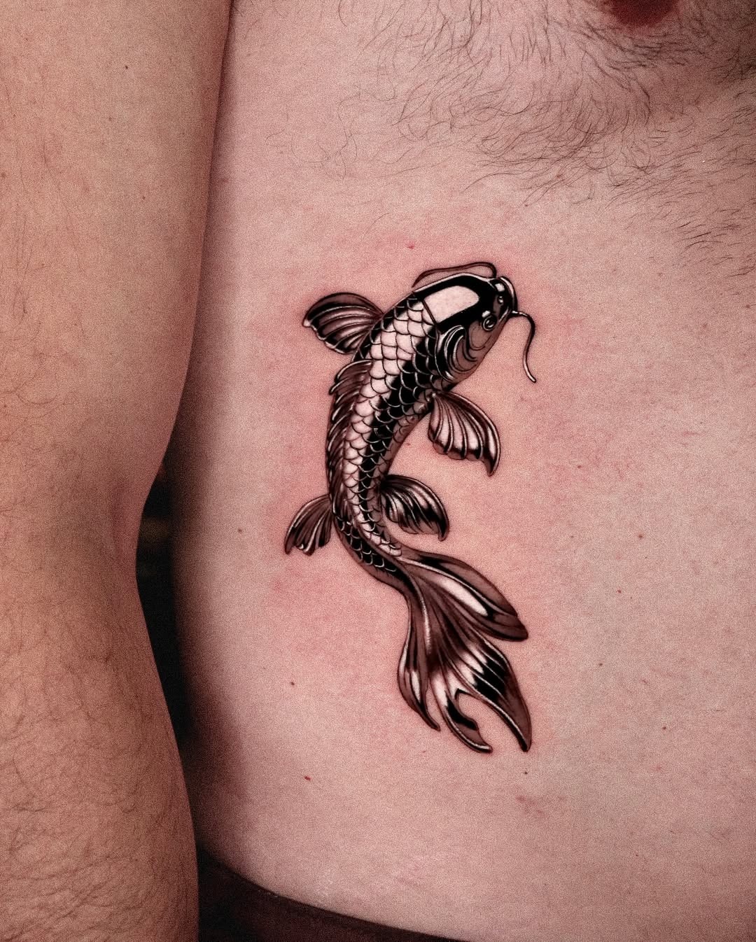 This elegant koi fish tattoo showcases intricate details and realistic shading.