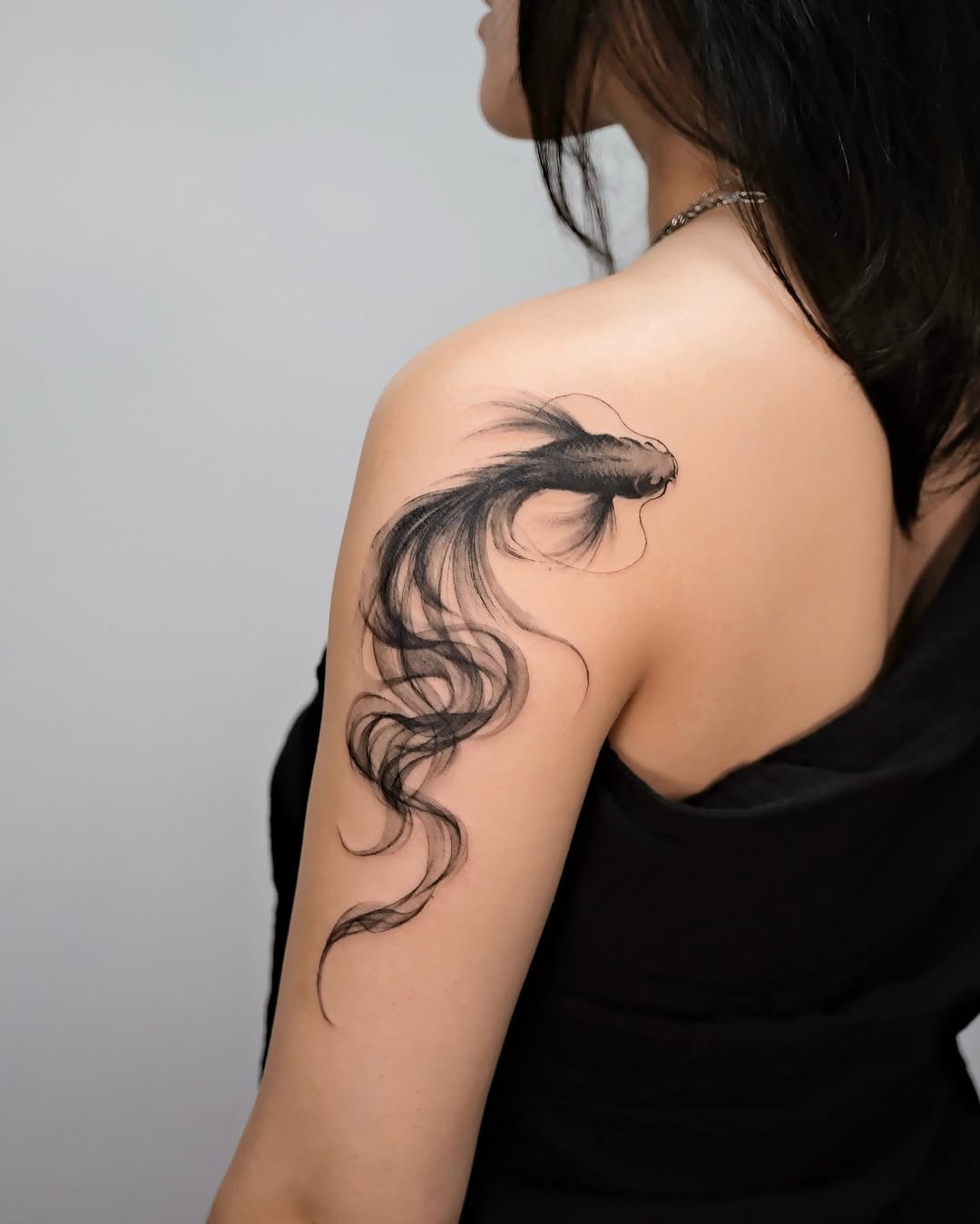 This beautiful koi fish tattoo showcases delicate lines and graceful movement.