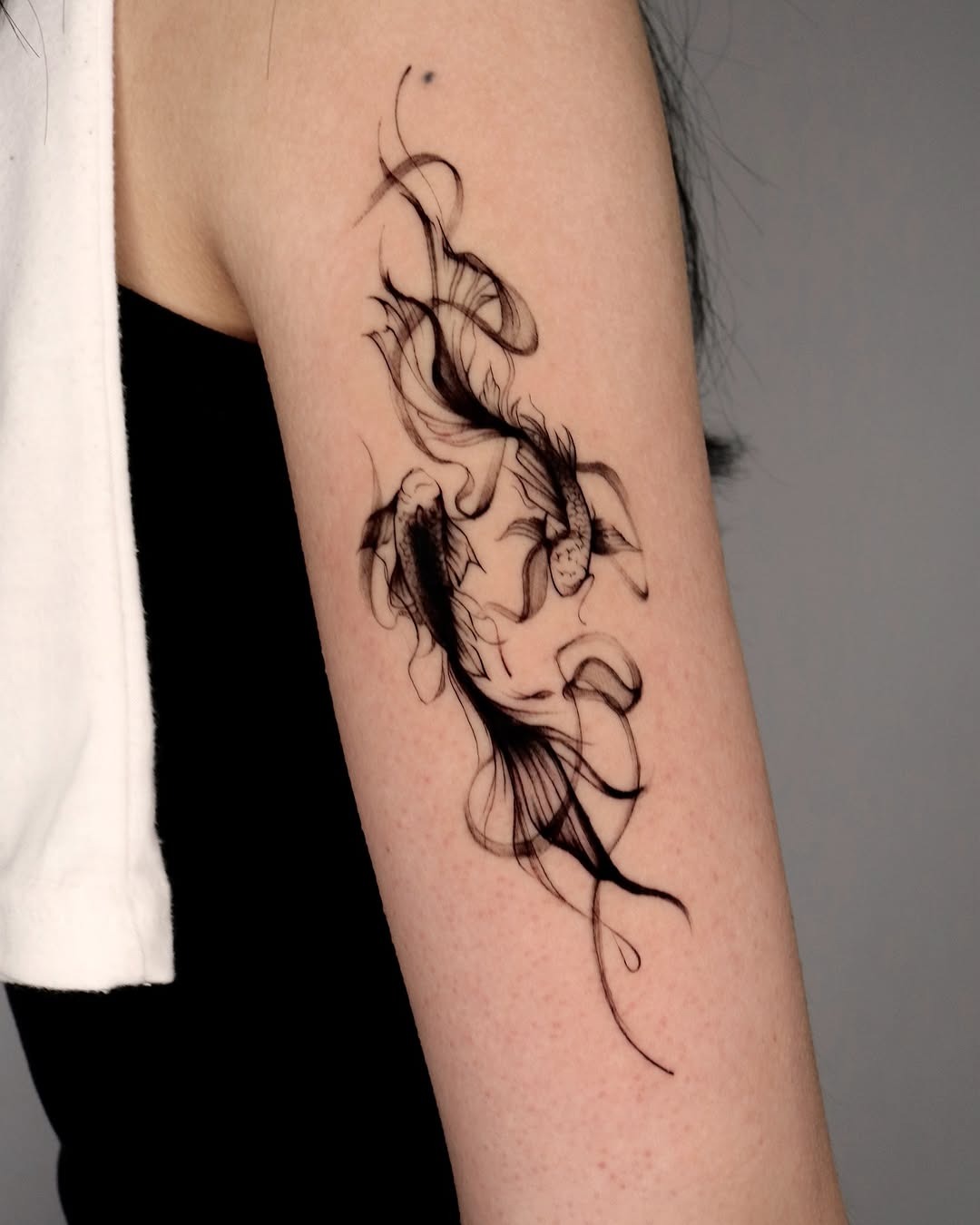This beautiful koi fish tattoo showcases delicate lines and graceful movement.