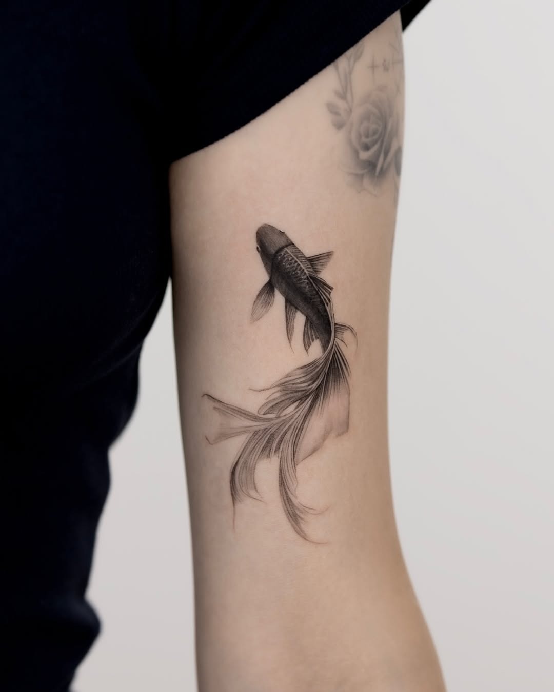 This stunning black and gray koi fish tattoo captures the essence of grace and fluidity.