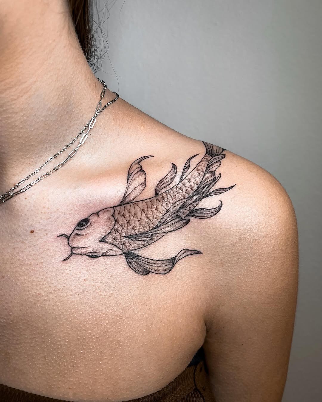 This stunning koi fish tattoo gracefully adorns the shoulder.