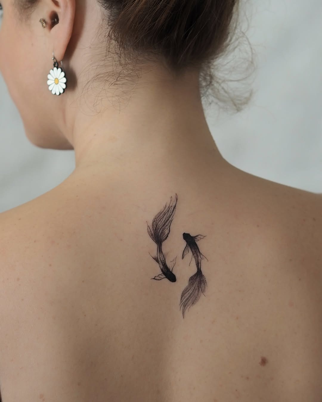 This tattoo features intricately designed koi fish, showing their delicate lines and textures.