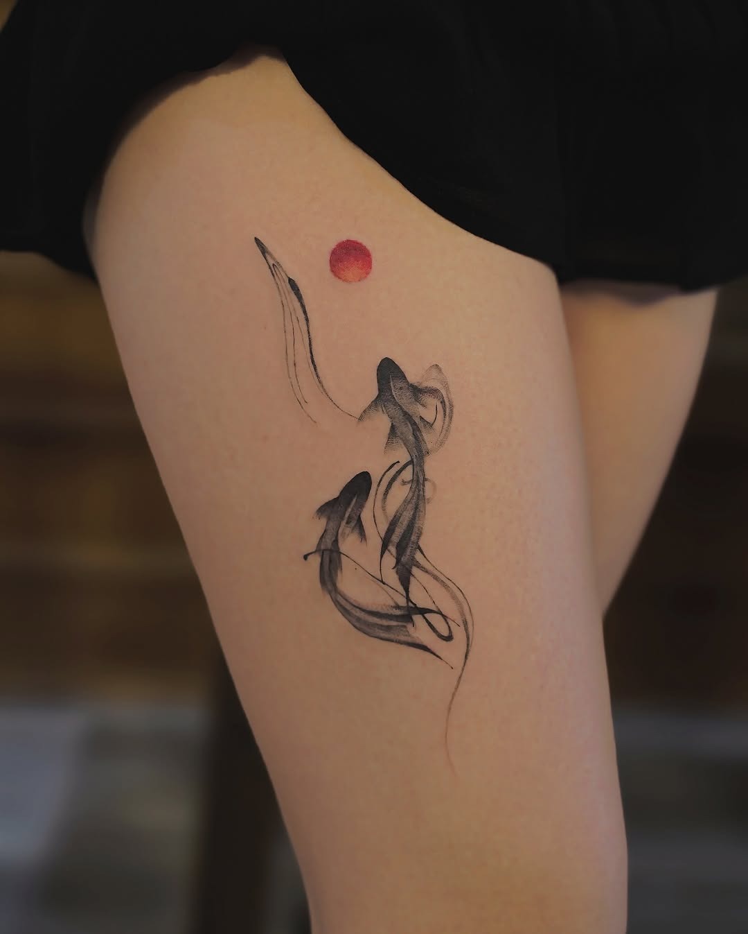 This tattoo showcases graceful koi fish swimming up towards a red sun.