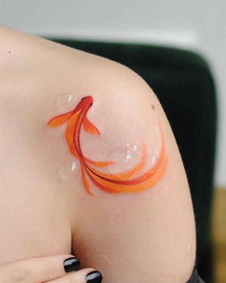 This stunning koi fish tattoo features bright orange and red hues, creating a captivating look on the shoulder.