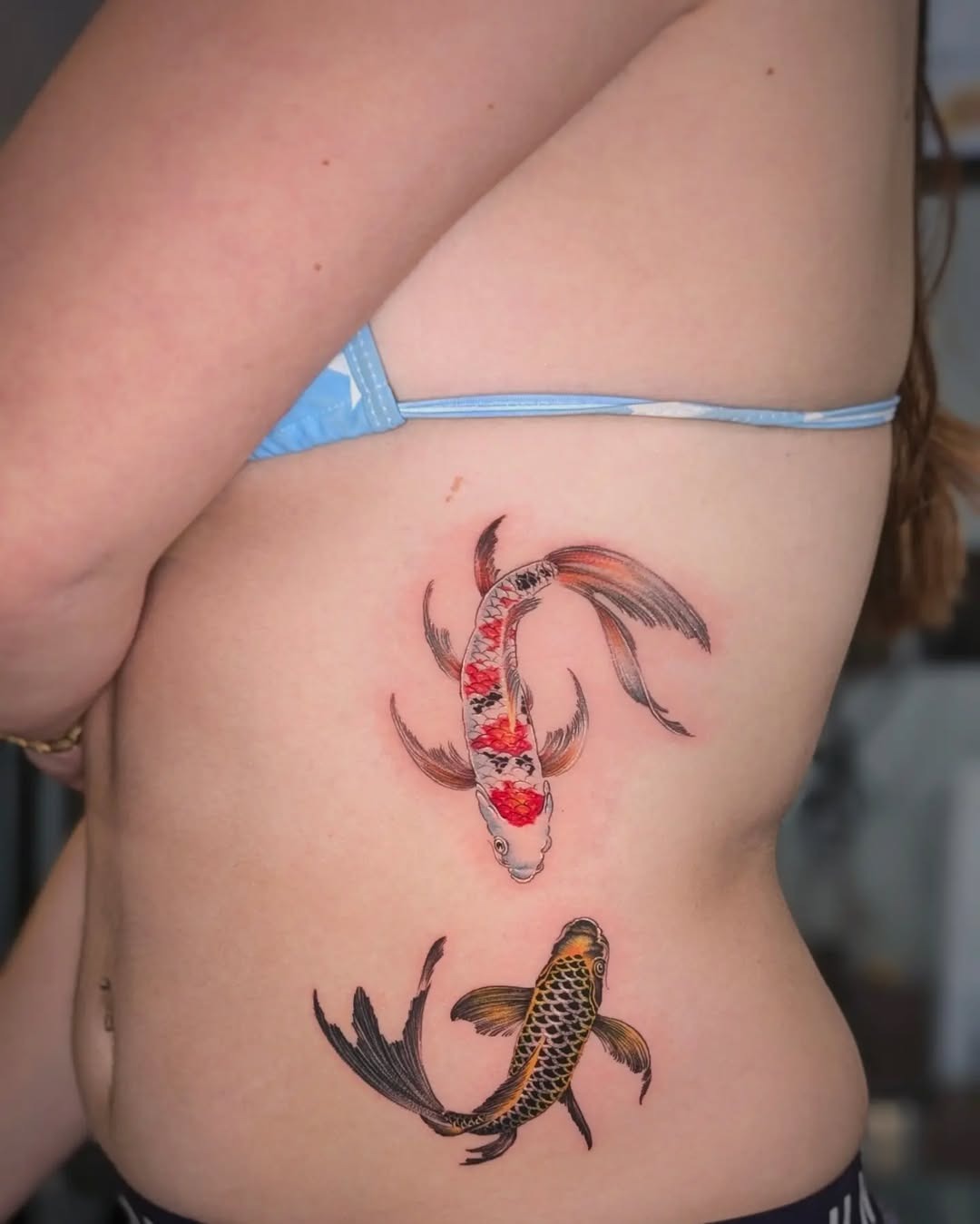 This tattoo showcases two beautiful koi fish swimming gracefully.