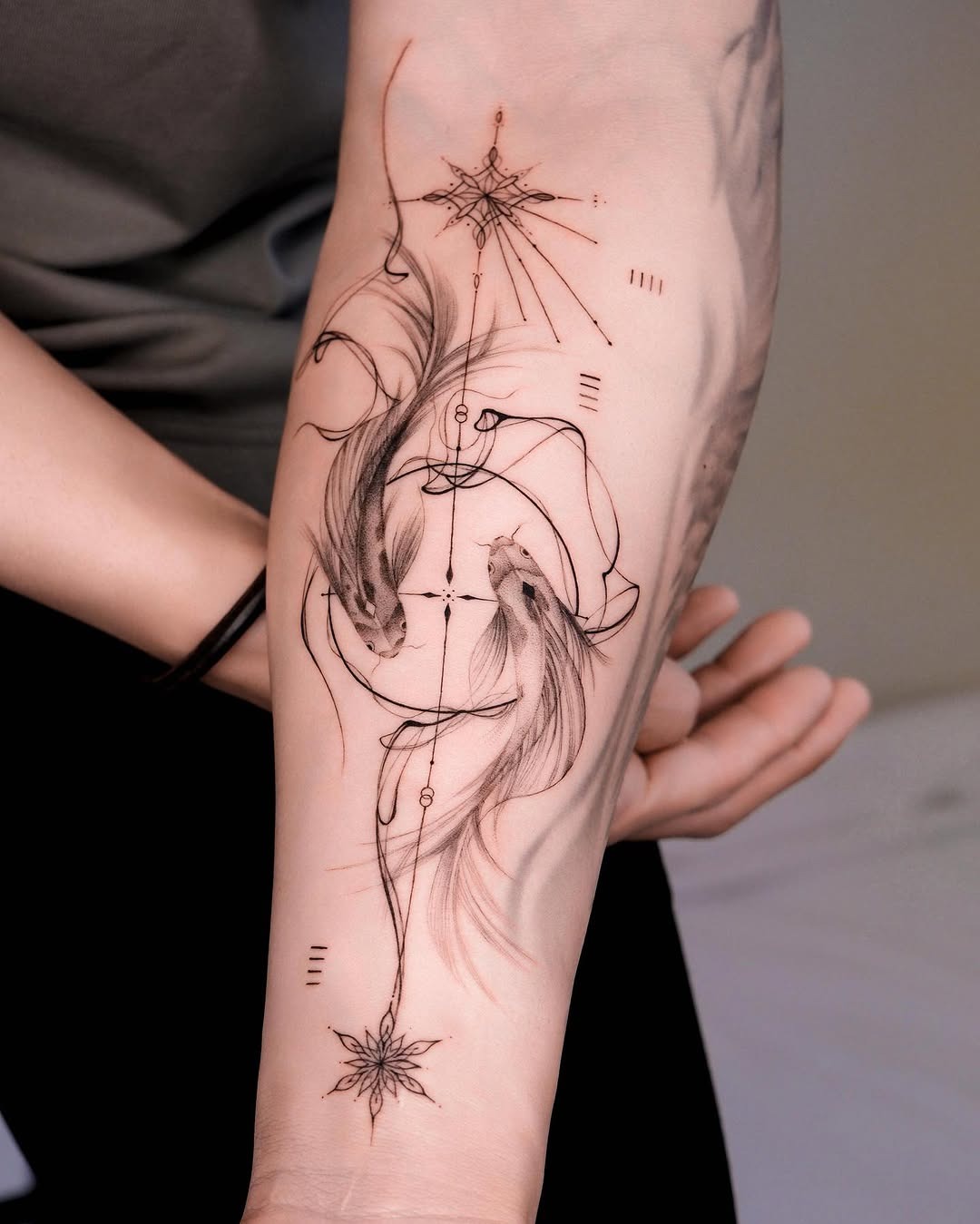 This tattoo features two koi fish intertwined in a graceful dance, beautifully outlined with fine black lines.